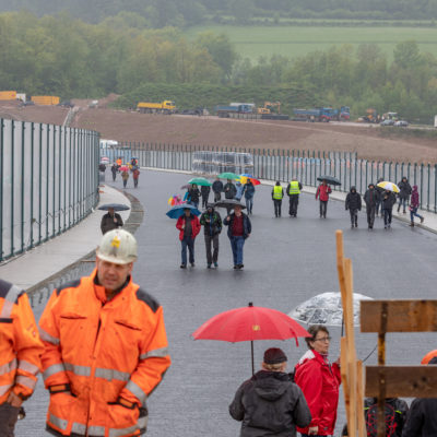 Menschen mit Regenschirmen laufen auf der Brücke