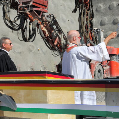 Zwei Pfarrer segnen Tunnelportal und Maschinen