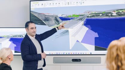 Ein Mann zeigt an einem Bildschirm eine 3D-Darstellung eines Bauwerksmodells